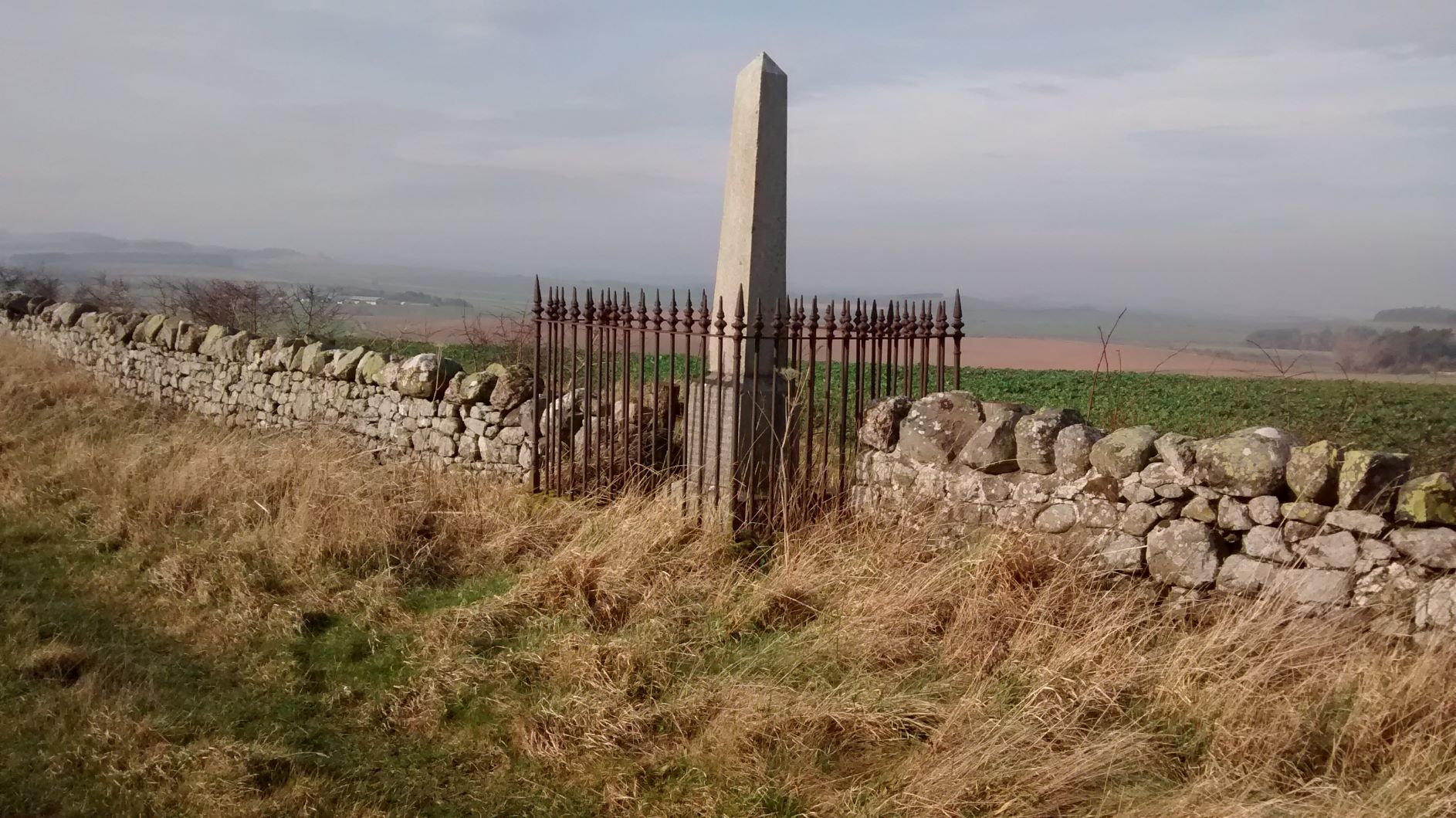 The Erskine monument is in the form of a granite obelisk on a plinth and is next to a grassy path
